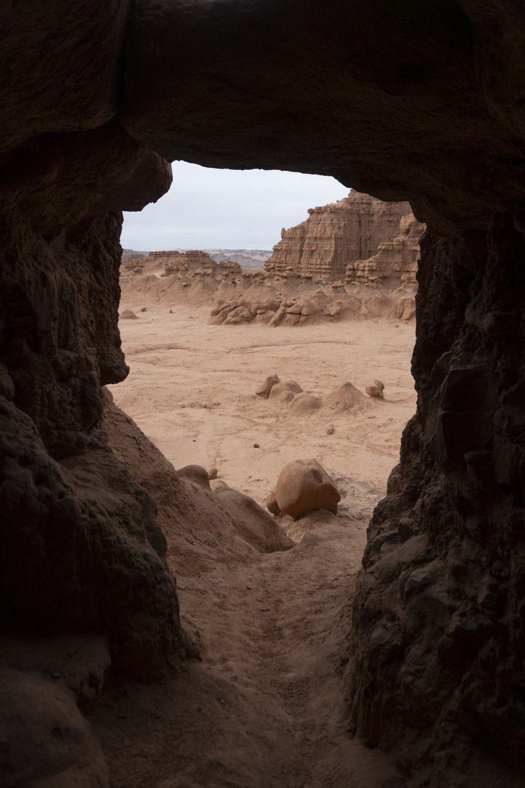 Goblin valley rocks visible through a cave opening